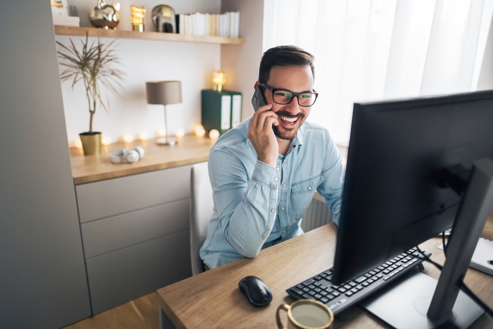 Smiling,Handsome,Freelancer,Working,Remotely,From,Home.,He,Is,Speaking Smiling,Handsome,Freelancer,Working,Remotely,From,Home.,He,Is,Speaking
