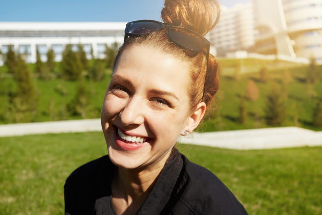 Headshot,Of,Happy,Pretty,Teenage,Girl,With,Bun,Hairstyle,Looking