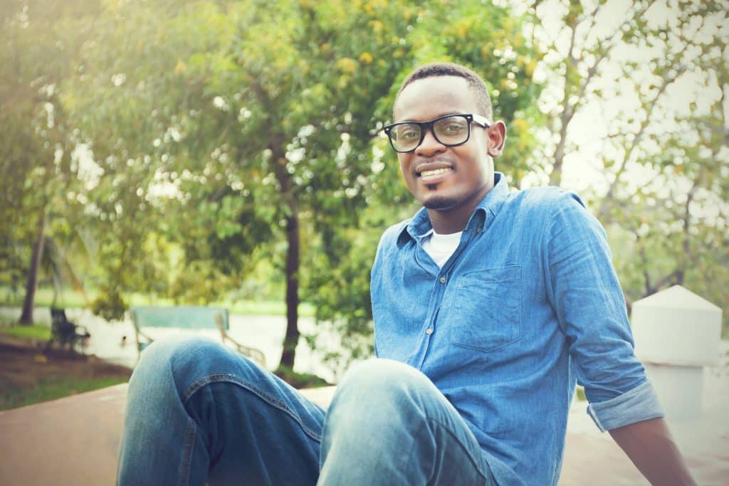 Happy,African,American,Man,Sitting,And,Smiling,In,The,Park