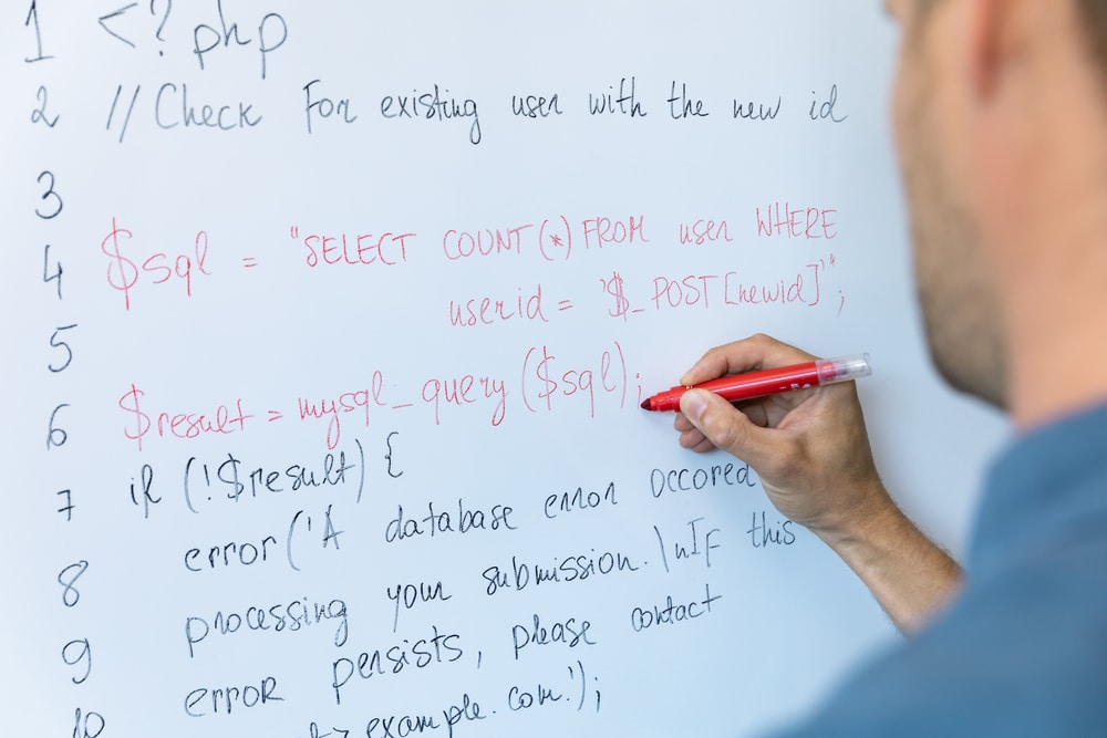 Teacher php. Man write on the Whiteboard.